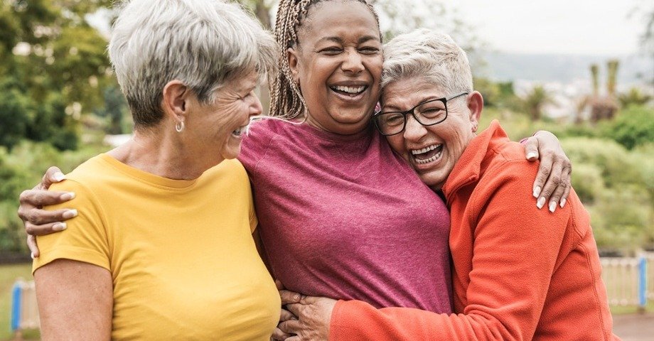 Group of 3 women laughing, smiling, and enjoying each other's company